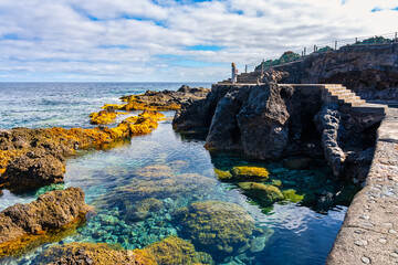 Tourist woman walking next to the rocks that form natural pools on the island of La Palma, Canary Islands. © josemiguelsangar