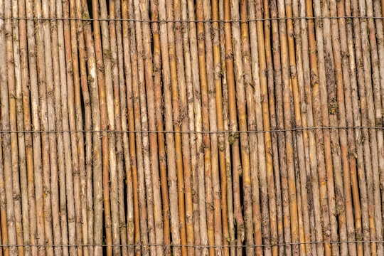 Mata z gałązek wierzby i drutu zdobiąca płot. Mata wykonana z naturalnych materiał&oacute;w, kt&oacute;ra zapewnia prywatność w ogrodzie i ozdabia go.