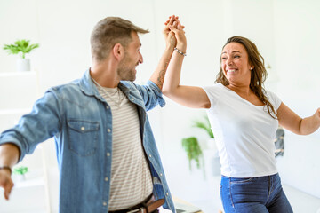 Happy couple dancing together at home