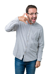 Fototapeta premium Handsome middle age elegant senior man wearing glasses over isolated background smiling doing phone gesture with hand and fingers like talking on the telephone. Communicating concepts.