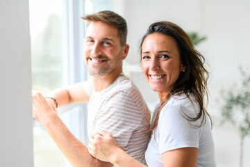 Fototapeta premium mid adult couple standing near of a window. Happy and romantic mature man embracing