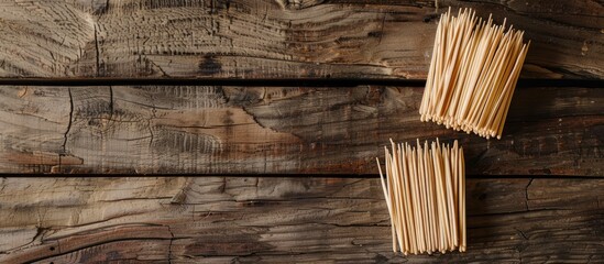 Wooden background with disposable toothpicks and holder arranged in a flat lay composition, featuring ample space for text in the image.