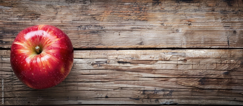 Poster horizontal wooden background showcasing a ripe red apple with copy space image available.