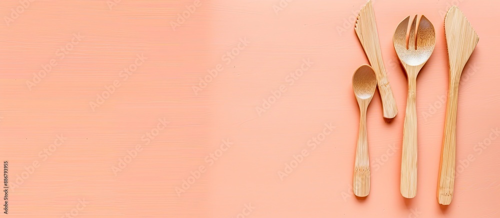 Poster wooden cutlery set on a peach backdrop with ample copy space image.
