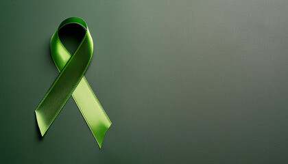 Green awareness ribbon on isolated green background. Symbol of support. Mental health awareness