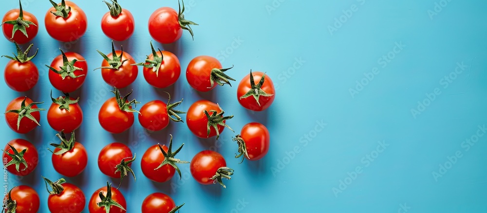 Poster Cherry tomatoes arranged with a background color of blue providing copy space image.