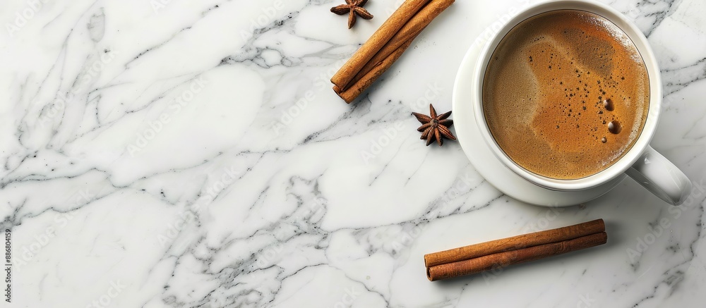 Poster top view of a cup with coffee and cinnamon sticks on a marble surface providing copy space image.