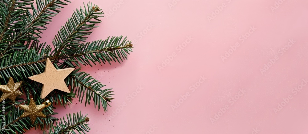 Poster craft paper-wrapped christmas tree branches on a pink backdrop, with a wooden star nearby, creating 