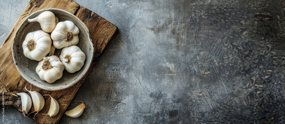 Aufkleber garlic bulb and clove in a ceramic bowl on a chopping block against a vintage grey backdrop, with sp