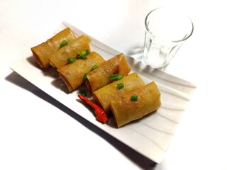 Fried spring rolls filled with vegetables and vermicelli on white plate