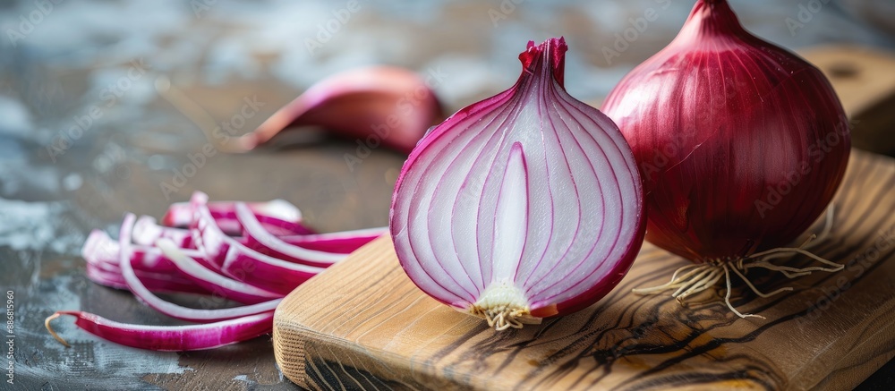 Poster half a red onion displayed on a wooden board with copy space image.