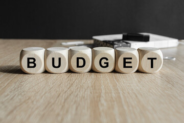 Financial planning concept . Word of budget word on wooden cubes. Beautiful black background,...