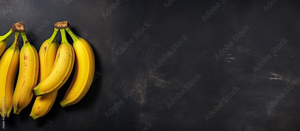 Poster Aerial perspective showing four bananas on a dark slate surface with copy space image to the right.