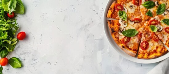 Top-down view of a plate with sliced pizza and salad leaves on a table, serving as a menu concept background with copy space for text.