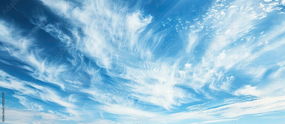 Poster A serene cloudscape with white wispy clouds against a blue sky, ideal as a background image for design projects with copy space. Conveys a sense of hope and peace, evoking a celestial theme.