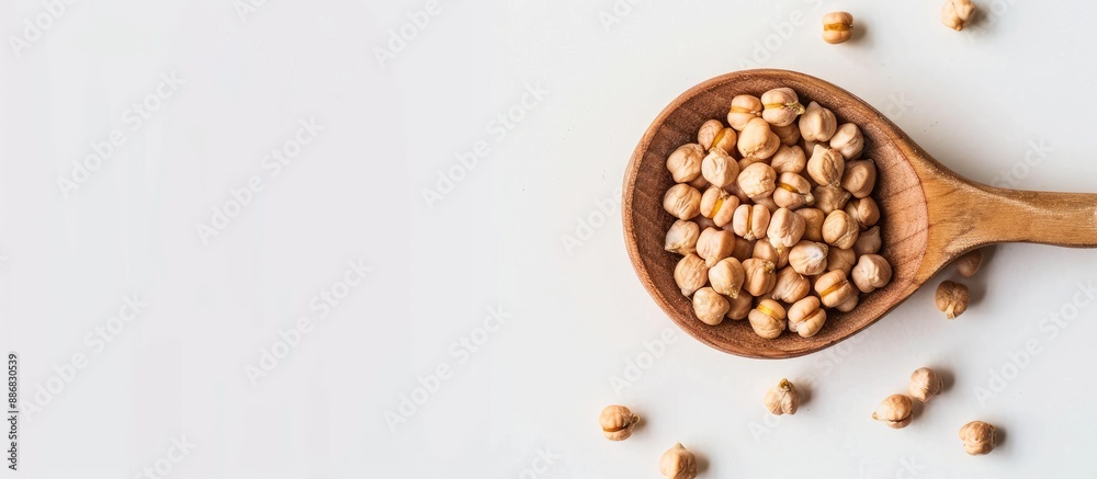 Poster top view of dry organic chickpeas in a wooden spoon on a white background with ample copy space imag