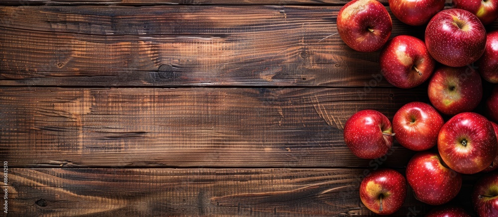 Poster Wooden background covered with apples. Flat lay view from the top with copy space image.