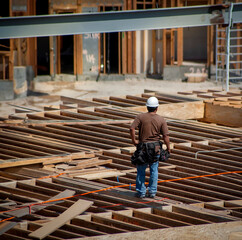 Above view of a construction worker standing on framing for a floor of a building at a construction...
