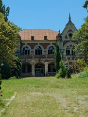An old mansion with a large balcony and a rusty roof.