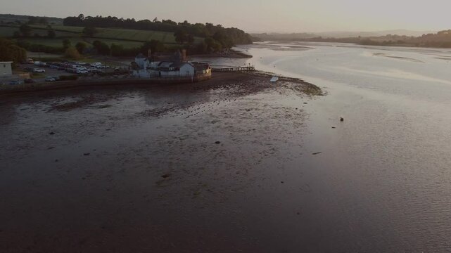 A drone view of the estuary of the River Teign, backlit by the setting sun, shot at Coombe Cellars, near Newton Abbot, Devon, England, United Kingdom, Europe
