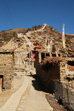 Many stairs are leading up to the Guru Rinpoche Statue and a stupa, pagoda in the traditional mountain village of Ngawal, Annapurna Circuiti Trek, Nepal