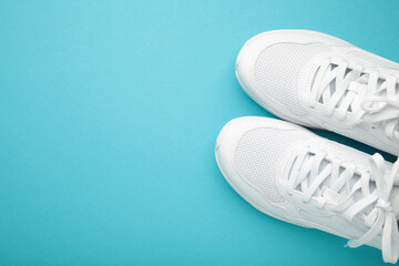 White sneakers on a blue background. Space for text