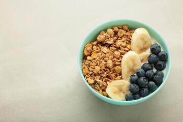 Oat raisin granola with fresh summer berries in a bowl on light background. Concept of healthy breakfast food, clean eating, dieting