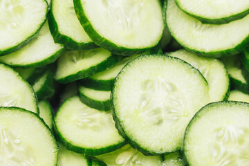 Cucumber slices pattern. Pile of round cucumber cuts texture. Green vegetable background. Cucumber cross section. Polish mizeria salad ingredients.