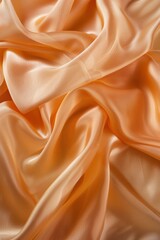 Fototapeta premium Orange fabric texture close-up. Crumpled silk or cotton material with smooth surface. Soft light fills blurred room background. Fashion design inspiration, textile pattern, interior decor element.