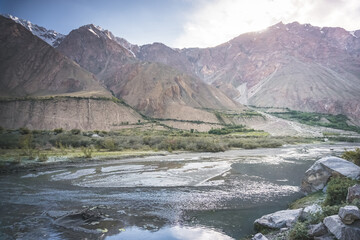 Noisy wide mountain river Panj flows in valley between Afghanistan and Tajikistan in Tien Shan mountains in Pamir in evening