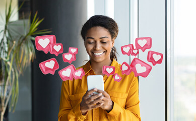 Black woman smiles as she looks at her phone. Heart icons surround her, representing notifications or likes on a social media app. The background features a simple office setting.
