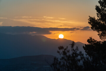 The sun hiding behind the mountains, summer evening