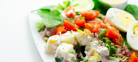 A plate of food with a salad, eggs, and a sauce