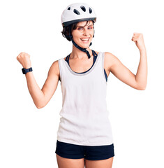 Beautiful young woman with short hair wearing bike helmet screaming proud, celebrating victory and success very excited with raised arms