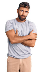Young hispanic man wearing casual clothes shaking and freezing for winter cold with sad and shock...