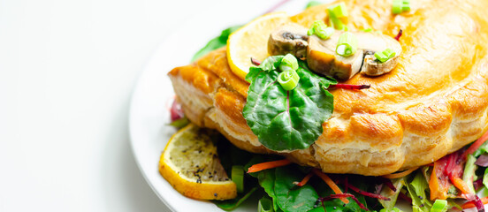 A plate of food with a meat dumpling and a lemon wedge on top