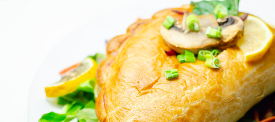 A plate of food with a meat dumpling and a lemon wedge on top