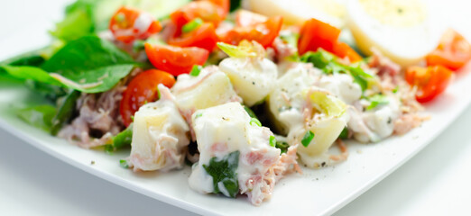 A plate of food with a salad, eggs, and a sauce