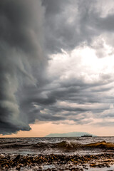 Romantic sunset on the beach with cloudy sky like a painting, view to Samothrace island