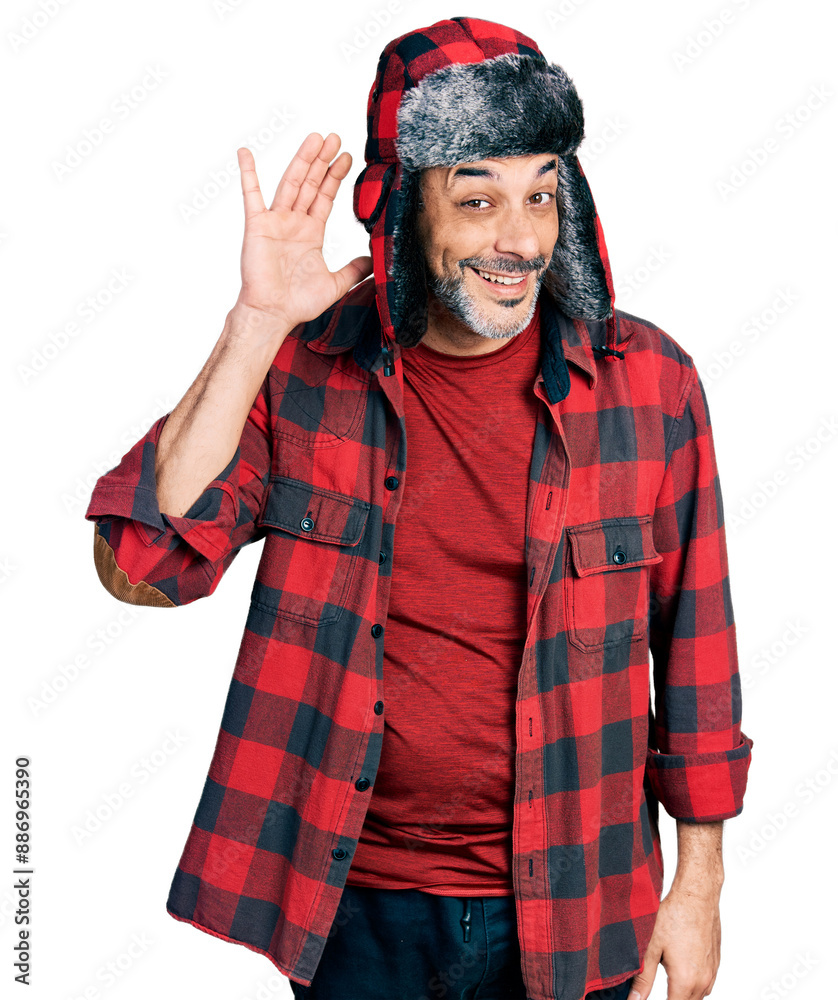 Poster Middle age hispanic man with grey hair wearing fluffy earmuff hat smiling with hand over ear listening an hearing to rumor or gossip. deafness concept.