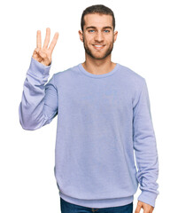 Naklejka premium Young caucasian man wearing casual clothes showing and pointing up with fingers number three while smiling confident and happy.
