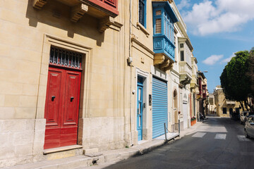 Charming streets of Malta with colorful doors and shutters on a sunny vacation day, capturing the picturesque Mediterranean architecture and vibrant holiday atmosphere.