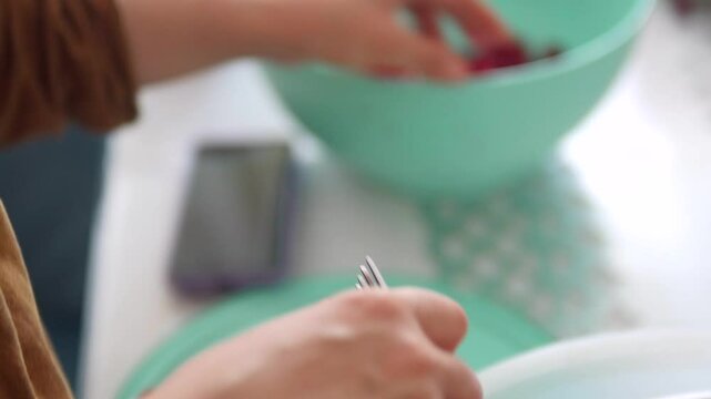 A woman pits cherries to make cherry jam,