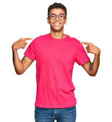 Young handsome african american man wearing casual clothes looking confident with smile on face, pointing oneself with fingers proud and happy.