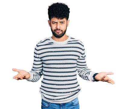 Young arab man with beard wearing casual striped sweater clueless and confused with open arms, no idea concept.