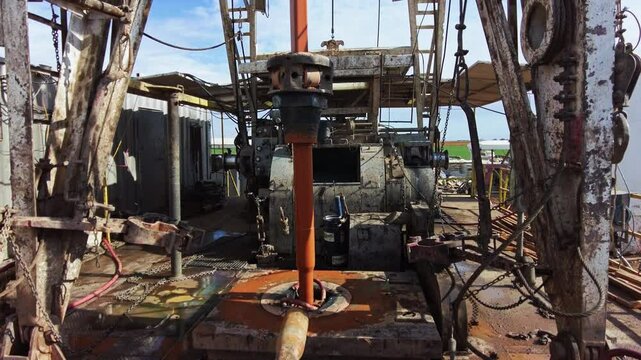 Metal borer rotates drilling the ground. Modern site for oil production in the field. Working equipment for natural resources boring.