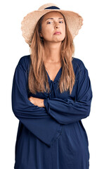 Fototapeta premium Middle age hispanic woman wearing summer hat relaxed with serious expression on face. simple and natural looking at the camera.