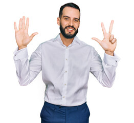 Fototapeta premium Young man with beard wearing business shirt showing and pointing up with fingers number eight while smiling confident and happy.