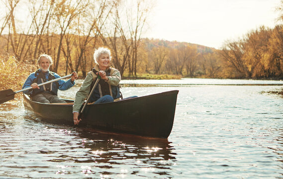 Lake, senior couple and rowing in nature with canoe for explore, adventure or retirement activity. Outdoor, river and elderly woman with man on boat for kayaking, holiday or weekend break in Sydney - Powered by Adobe