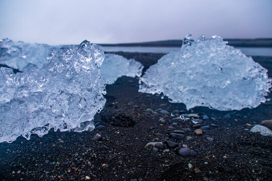 stranded icebergs on a dark pebbly beach in j&ouml;kuls&aacute;rl&oacute;n in iceland